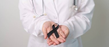 Melanoma ve cilt kanseri, aşı hasarı farkındalığı ayı ve huzur içinde yatma kavramları. Doktor elinde siyah kurdele tutuyor.
