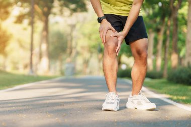 Koşarken kas ağrısı çeken genç bir erkek. Runners Knee veya Patellofemoral Pain Sendromu, osteoartrit ve Patellar Tendinitis yüzünden koşucunun diz ağrısı var. Spor yaraları ve tıbbi konsept