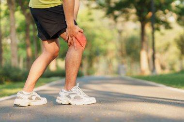 Koşarken kas ağrısı çeken genç bir erkek. Runners Knee veya Patellofemoral Pain Sendromu, osteoartrit ve Patellar Tendinitis yüzünden koşucunun diz ağrısı var. Spor yaraları ve tıbbi konsept