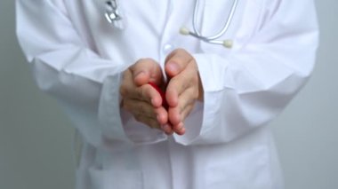 Doktorlar hastanede kırmızı kalp şeklinde tutuyorlar. Aşk, donör, dünya kalp günü, dünya sağlık günü, CSR bağışı ve sigorta kavramları