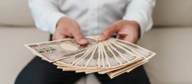 man hand holding Japanese Yen banknote stack. Thousand Yen money. Japan cash, Tax, Recession Economy, Inflation, Investment, finance and shopping payment concepts