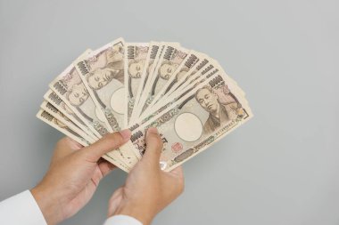 man hand holding Japanese Yen banknote stack. Thousand Yen money. Japan cash, Tax, Recession Economy, Inflation, Investment, finance and shopping payment concepts