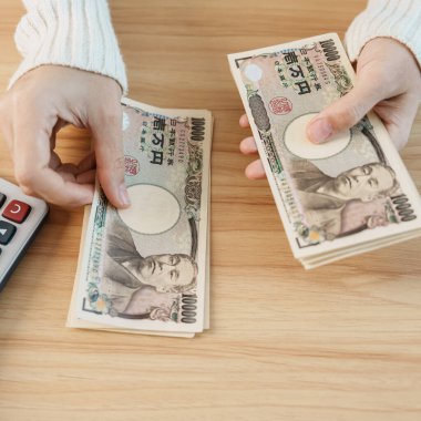 Woman hand counting Japanese Yen banknote with calculator. Thousand Yen money. Japan cash, Tax, Recession Economy, Inflation, Investment, finance, savings, salary and payment concepts