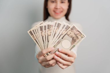 Woman hand holding Japanese Yen banknote stack. Thousand Yen money. Japan cash, Tax, Recession Economy, Inflation, Investment, finance and shopping payment concepts