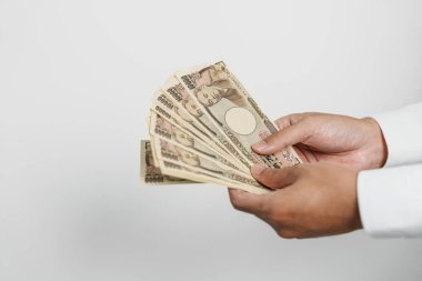 man hand holding Japanese Yen banknote stack. Thousand Yen money. Japan cash, Tax, Recession Economy, Inflation, Investment, finance and shopping payment concepts
