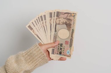 Woman hand holding Japanese Yen banknote stack. Thousand Yen money. Japan cash, Tax, Recession Economy, Inflation, Investment, finance and shopping payment concepts