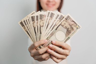 Woman hand holding Japanese Yen banknote stack. Thousand Yen money. Japan cash, Tax, Recession Economy, Inflation, Investment, finance and shopping payment concepts