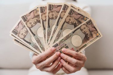 Woman hand holding Japanese Yen banknote stack. Thousand Yen money. Japan cash, Tax, Recession Economy, Inflation, Investment, finance and shopping payment concepts