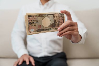 man hand holding Japanese Yen banknote stack. Thousand Yen money. Japan cash, Tax, Recession Economy, Inflation, Investment, finance and shopping payment concepts