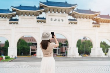 Tayvan 'ı ziyaret eden bir kadın gezgin, Taipei' deki National Chiang Kai shek Memorial ya da Hall Freedom Square 'de fotoğraf çeken bir turist. Şehir simgesi ve popüler gösteriler. Asya Seyahat Konsepti