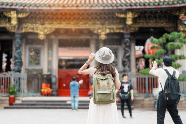 Tayvan 'da gezen bir kadın gezgin, Longshan Tapınağı' nda gezen şapkalı bir turist, Wanhua Bölgesi, Taipei Şehri 'ndeki Çin halk dinî tapınağı. Şehir simgesi ve popüler. Seyahat ve Tatil kavramı