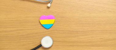 Panseksüel Onur Günü ve LGBT gurur ayı konsepti. Lezbiyen, Gey, Biseksüel, Transseksüel, Eşcinsel ve Panseksüel Topluluğu için steteskop içeren pembe, sarı ve mavi kalp şekli