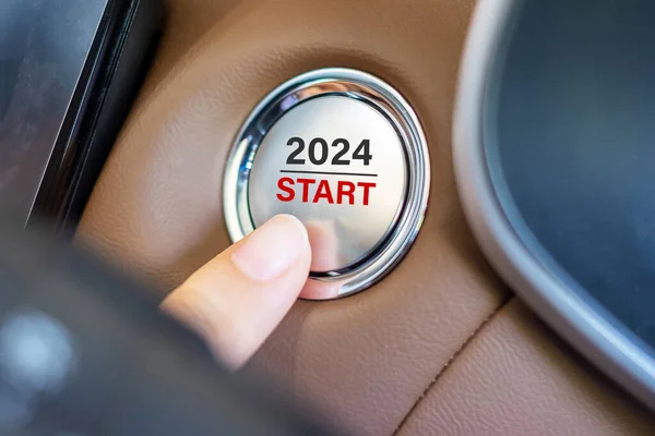 手指按车内装有2024 Start文字的汽车点火按钮 新年你 创新和规划概念 — 图库照片
