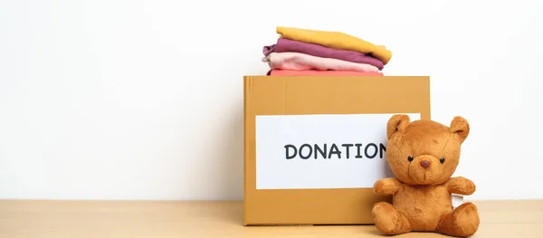 子供の寄付 ボランティア 寄付と配達の概念 貧しい人々 ホームレスの人々を支援し 助けるために自宅で募金箱で人形や服を負担します テキストのコピースペース — ストック写真