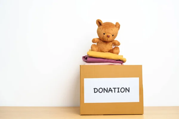 子供の寄付 ボランティア 寄付と配達の概念 貧しい人々 ホームレスの人々を支援し 助けるために自宅で募金箱で人形や服を負担します テキストのコピースペース — ストック写真