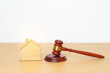 Emlak Hukuku, Ev Sigortası, Emlak Vergisi, Açık Artırma ve Açık Artırma Konsepti. Adliyedeki masasında tokmak adalet çekici olan küçük oyuncak ev modeli..