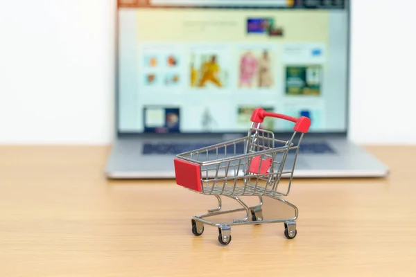 Shopping cart and laptop computer with marketplace website. Online Shopping, technology, ecommerce, SEO, Search Engine Optimization, Advertising, keyword and online payment concept