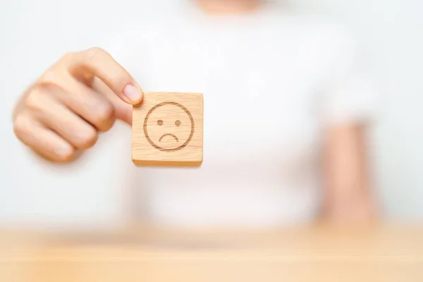 stock image Hand choosing unhappy angry face from Emotion block. customer review, bad experience, negative feedback, satisfaction, survey, rating service, assessment, mood, world mental health day concepts