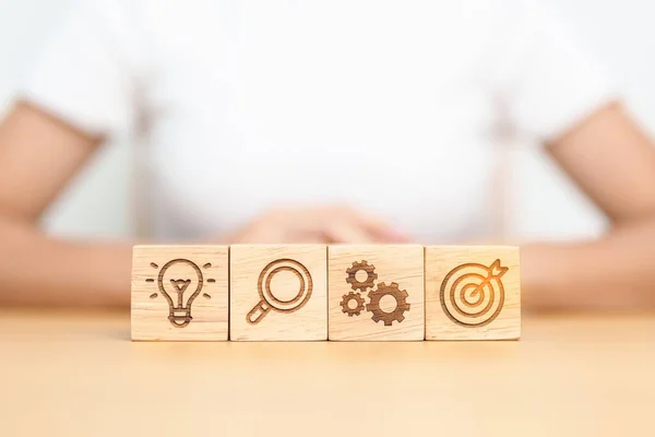 stock image dartboard, Gear, magnifying and Lightbulb icon block on table. business planning process, goal, strategy, target, mission, action, research, teamwork and idea concept