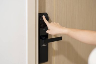 Hand using fingerprint scan for smart digital door lock while open or close the door at home or apartment. NFC Technology, keycard, PIN number, smartphone and contactless lifestyle concepts clipart