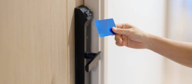 Evdeki ya da dairedeki kapıyı açarken ya da kapatırken akıllı dijital kapı kilidi için anahtar kartı kullanılıyor. NFC Teknoloji, Parmak izi taraması, PIN numarası, akıllı telefon ve irtibatsız yaşam tarzı kavramları