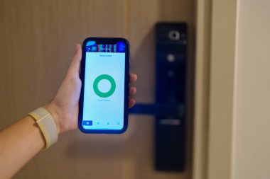 Evde ya da dairede dijital kapı kilidi açmak için akıllı telefon kullanıyor. NFC Teknoloji, Parmak izi taraması, anahtar kartı, PIN numarası, akıllı telefon, elektrik ve irtibatsız yaşam tarzı kavramları