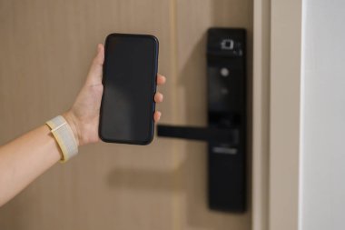 Evde ya da dairede dijital kapı kilidi açmak için akıllı telefon kullanıyor. NFC Teknoloji, Parmak izi taraması, anahtar kartı, PIN numarası, akıllı telefon, elektrik ve irtibatsız yaşam tarzı kavramları