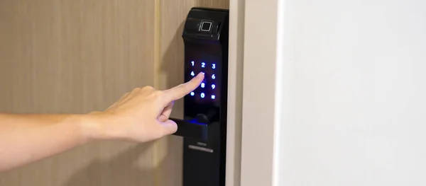 stock image Hand press PIN number for smart digital door lock while open or close the door at home or apartment. NFC Technology, Fingerprint scan, keycard, smartphone and contactless lifestyle concepts