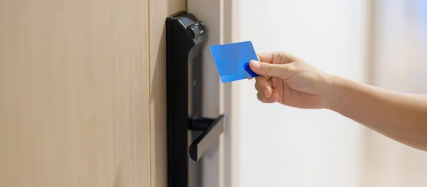 stock image Hand using keycard for smart digital door lock while open or close the door at home or apartment. NFC Technology, Fingerprint scan, PIN number, smartphone and contactless lifestyle concepts