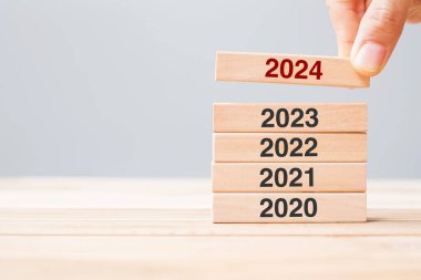 2024 block over 2023 and 2022 wooden building on table background. Business planning, Risk Management, Resolution, strategy, solution, goal, New Year New You and happy holiday concepts