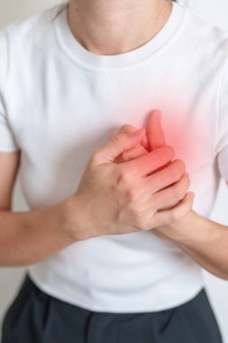 Göğüs ağrısı çeken bir kadın. Kalp hastalığı, anjin hastalığı ve semptom kalp krizi hastalığı kardiyovasküler, Atheroskleroz, Hipertansif, Göğüs Kanseri Bilinci, Dünya Kalp Günü ve Sağlık Konsepti