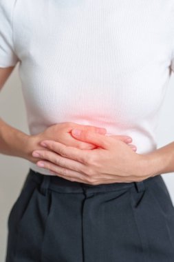 Karın ağrısı çeken bir kadın. Yumurtalık ve rahim ağzı kanseri, rahim ağzı rahatsızlığı, endometriyozis, histerektomi, rahim fibroidi, üreme sistemi, adet görme, ishal, sindirim sistemi ve hamilelik.