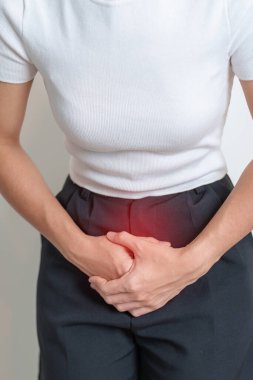 Karın ağrısı çeken bir kadın. Yumurtalık ve rahim ağzı kanseri, rahim ağzı rahatsızlığı, endometriyozis, histerektomi, rahim fibroidi, üreme sistemi, adet görme, ishal, sindirim sistemi ve hamilelik.