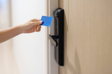 Evdeki ya da dairedeki kapıyı açarken ya da kapatırken akıllı dijital kapı kilidi için anahtar kartı kullanılıyor. NFC Teknoloji, Parmak izi taraması, PIN numarası, akıllı telefon ve irtibatsız yaşam tarzı kavramları