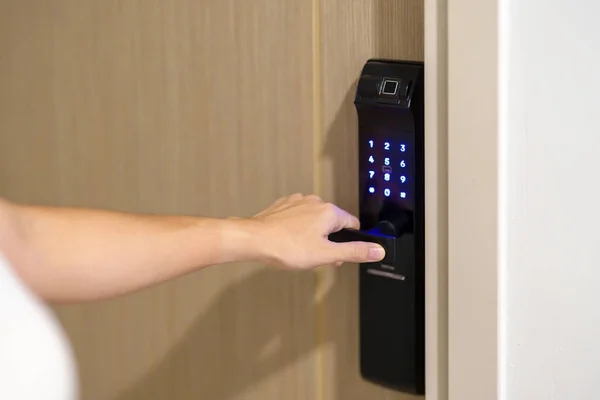 Hand using smart digital door lock while open or close the door at home or apartment. NFC Technology, Fingerprint scan, keycard, PIN number, smartphone, electrical and contactless lifestyle concepts