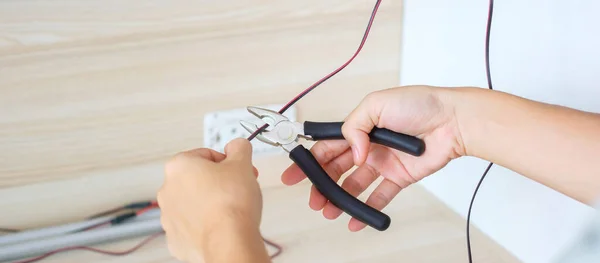 stock image Electrician cuts electrical wires with pliers, Wiring cables installation for socket plug. Fixing, Renovation, Repair, service and development of home and apartment concepts