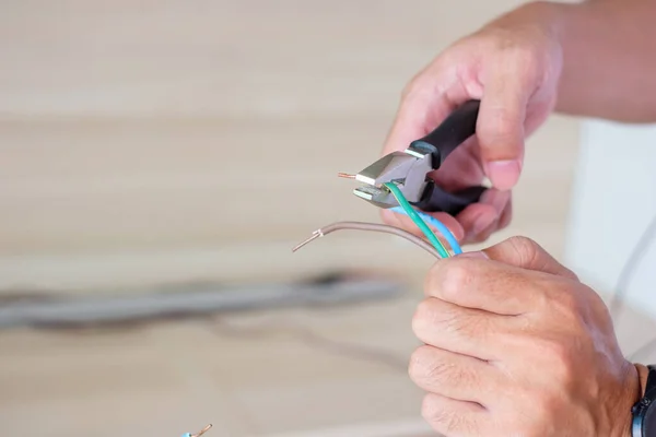 stock image Electrician cuts electrical wires with pliers, Wiring cables installation for socket plug. Fixing, Renovation, Repair, service and development of home and apartment concepts