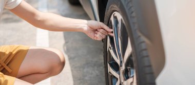 Kadın sürücü, lastikleri şişirerek araç lastiklerini şişiriyor, hava basıncını ölçmek için lastik valf kapağını çıkarıyor ve benzin istasyonunda araba tekerleğini dolduruyor. self servis, bakım ve güvenlik