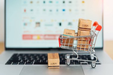Dizüstü bilgisayarında alışveriş arabası olan kutular. Çevrimiçi alışveriş, Pazar yeri platformu web sitesi, teknoloji, ekommerce, nakliye teslimatı, lojistik ve çevrimiçi ödeme kavramları