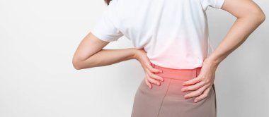 Gri arka planda kas ağrısı olan yetişkin bir kadın. Piriforis Sendromu, bel ağrısı ve omurga baskısı nedeniyle sırt ağrısı çeken yaşlı bir kadın. Ofis sendromu ve tıbbi konsept