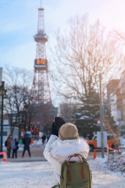 Sapporo 'da kadın turist, Kazaklı Gezgin kışın Kar' la Sapporo kulesini geziyor. Japonya 'nın Hokkaido şehrinde önemli ve popüler bir yer. Seyahat ve Tatil kavramı