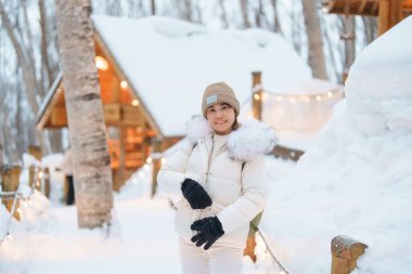 Furano 'yu ziyaret eden kadın turist, kazaklı gezgin kışın Snow' la Ningle Terrace Cottages 'ı gezen gezgin. Japonya 'nın Hokkaido şehrinde önemli ve popüler bir yer. Seyahat ve Tatil kavramı