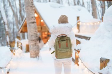 Furano 'yu ziyaret eden kadın turist, kazaklı gezgin kışın Snow' la Ningle Terrace Cottages 'ı gezen gezgin. Japonya 'nın Hokkaido şehrinde önemli ve popüler bir yer. Seyahat ve Tatil kavramı