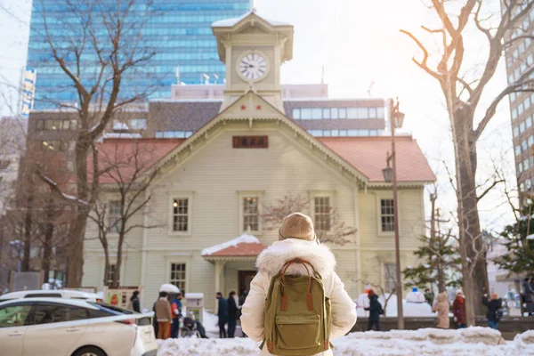 stock image Woman tourist Visiting in Sapporo, Traveler in Sweater sightseeing Sapporo Clock tower with Snow in winter. landmark and popular for attractions in Hokkaido, Japan. Travel and Vacation concept