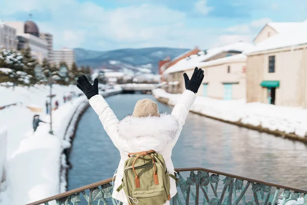 Otaru 'yu ziyaret eden kadın turist, süveter giyen mutlu gezgin kış mevsiminde Otaru kanalını geziyor. Japonya 'nın Hokkaido şehrinde önemli ve popüler bir yer. Seyahat ve Tatil kavramı