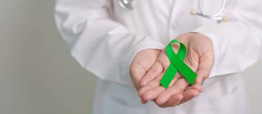 Dünya Akıl Sağlığı Günü için yeşil kurdeleli doktor, karaciğer, safra kesesi, safra kesesi, rahim ağzı, böbrek kanseri ve lenfoma farkındalığı ayı. Sağlık ve dünya kanser günü konsepti