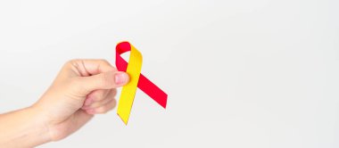 Kırmızı ve sarı kurdele tutan kadın. Dünya Hepatit Günü Farkındalık Ayı, 28 Temmuz, Karaciğer kanseri, Sarılık, Siroz, Başarısızlık, Büyümüş, Hepatik Ensefalopati ve Sağlık Konsepti