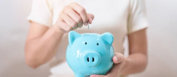 Money Saving for Future Plan, Retirement fund, Pension, Investment, Wealth Business and Financial concepts. hand holding and putting into piggy bank, Money Counting for World Savings day and Donate