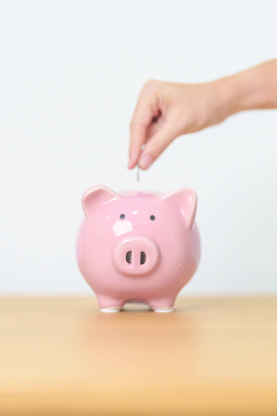 Money Saving for Future Plan, Retirement fund, Pension, Investment, Wealth Business and Financial concepts. hand holding and putting into piggy bank, Money Counting for World Savings day and Donate