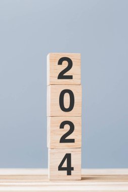Masa arkasında 2024 yazı olan tahta küp bloğu. Çözüm, plan, gözden geçirme, hedef, başlangıç ve yeni yıl tatili kavramları